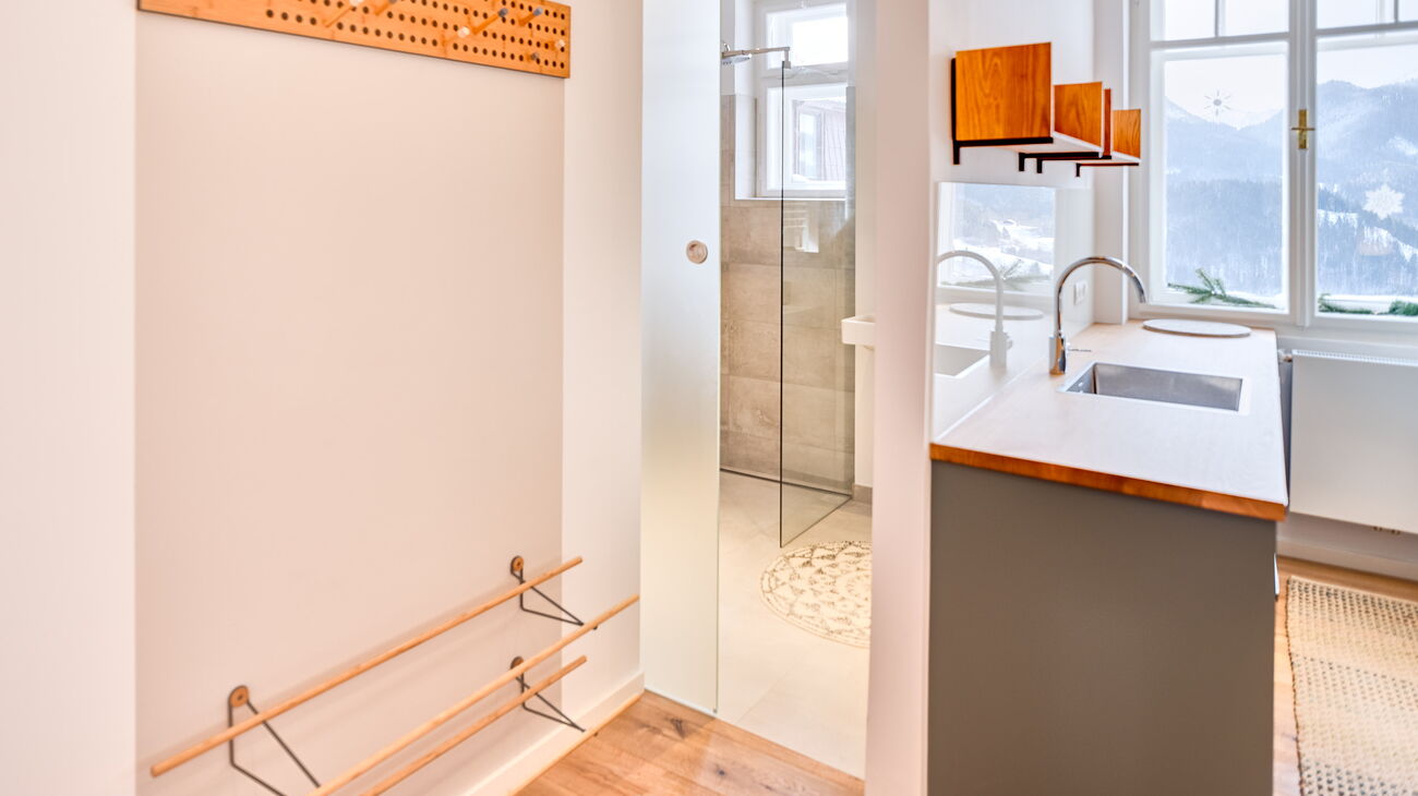 Vorzimmer mit Holz-Wandgarderobe, Schuhregal, Blick ins Bad und in die Küche
